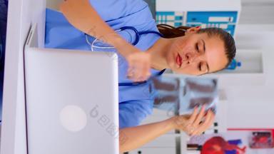 垂直视频医疗女人<strong>护士</strong>持有<strong>病人</strong>射线照相法打字移动PC