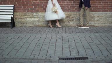 新娘新郎走城市年轻的可爱的婚礼夫妇新娘花花束