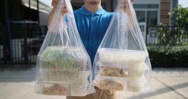 食物交付男人。将塑料袋购物在线超市女客户端服务客户前面房子表达杂货店冠状病毒科维德正常的生活方式