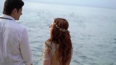 新婚夫妇走海滩海晚上日落持有手拥抱浪漫的海洋