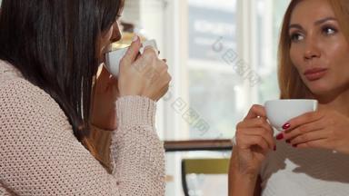 快乐<strong>女性朋友</strong>会说话的杯咖啡舒适的面包店商店