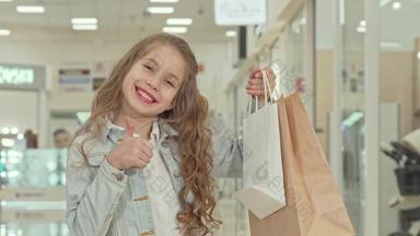 快乐可爱的女孩显示拇指<strong>购物购物</strong>中心
