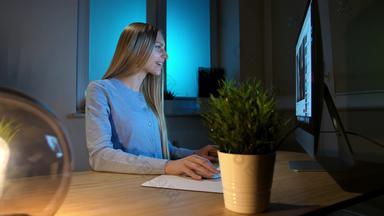 微笑女人工作电脑晚上微笑女网纹衬衫坐着基斯小灯木桌子上兴奋地电脑监控写作信息