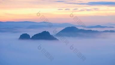 间隔拍摄春天有雾的早....森林景观视图雄伟的山峰减少照明雾深谷完整的色彩斑斓的雾岩石山坚持太阳