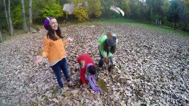 家庭孩子们扔秋天叶子空气替身慢运动