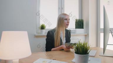 女人庆祝成功办公室优雅的金发碧眼的女坐着工作场所持有<strong>手包</strong>现金惊讶监控扔钱空气幸福的使手势