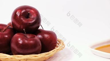 滑块拍摄桩红色的苹果红色的苹果白色板蜂蜜倒蜂蜜孤立的白色背景