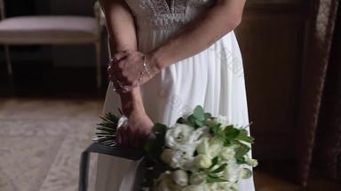 年轻的新娘婚礼衣服持有花束花在室内白色奢侈品礼服时尚