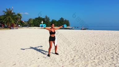 美丽的夫人<strong>黑色</strong>的<strong>比基尼</strong>横向手臂锻炼蓝色的哑铃中间白色沙子海滩印尼