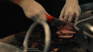 关闭手持有烟熏胸肉切割董事会很快切片煮熟的牛肉肉薄片烧烤板餐厅