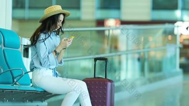 年轻的女人机场休息室等待飞行飞机高加索人女人智能手机等待房间