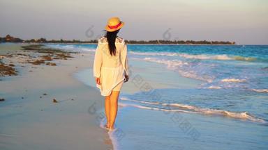 年轻的美丽的女人热带海滨日落快乐女孩衣服晚上海滩慢运动视频