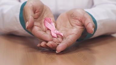 关闭女医生持有粉红色的丝带<strong>乳房</strong>癌症意识