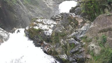 关闭瀑布泰国瀑布流动下降打击巨大的黑色的石头瀑布花岗岩山热带森林美丽的自然景点水下降岩石山
