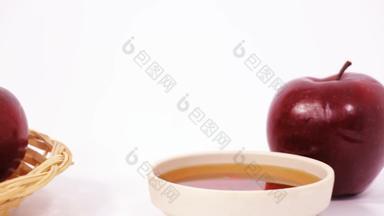 滑块拍摄桩红色的<strong>苹果</strong>红色的<strong>苹果</strong>碗<strong>蜂蜜</strong>孤立的白色背景