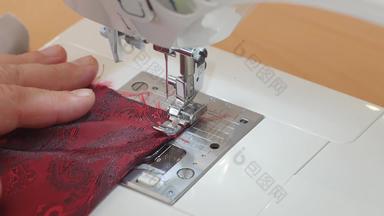 特写镜头缝纫机针运动针迅速移动裁缝缝纫红色的佩斯利衬里织物缝纫工作室车间过程西装使