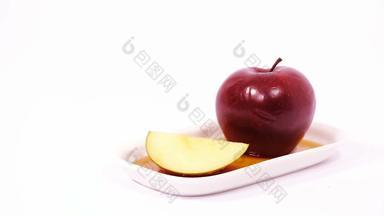 红色的苹果红色的苹果片白色板蜂蜜孤立的白色背景