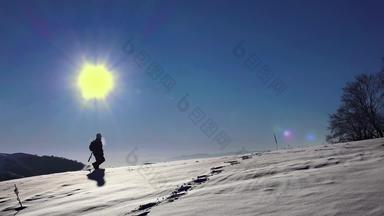 徒步旅行者男人。走雪探险旅程脚脚陡峭的雪冬天娱乐活动体育运动太阳背光轮廓地平线呃股票镜头