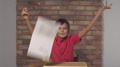 孩子坐着桌子上持有白板纸上的内容刻字自由背景红色的砖墙