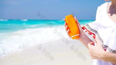 防晒霜女人应用晒黑乳液显示瓶美丽的微笑快乐女人晒黑奶油塑料容器海滩夏天旅行假期