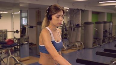 女运动员有氧运动机器听播放列表耳机