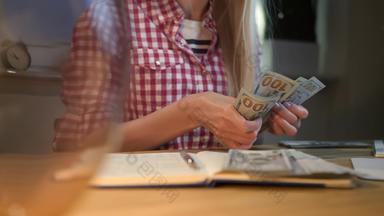 女人计数现金工作桌子上有吸引力的金发碧眼的女网纹衬衫坐着晚上房间木表格灯电脑计数包钞票手