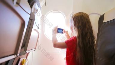 可爱的女孩旅行飞机坐着窗口孩子采取照片<strong>云</strong>天空坐着飞机窗口