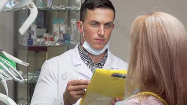 年轻的男性牙医会说话的女病人检查医疗论文