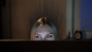 女人窥视电脑监控晚上作物视图美丽的女坐着晚上电脑相机前监控黑暗窗口模糊背景