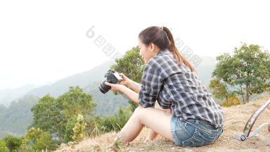 年轻的活跃的亚洲旅游女人旅行摄影师背包采取图片数字相机的观点山自然视图检查图片屏幕照片微笑