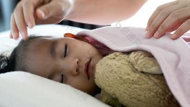关闭可爱的亚洲婴儿女孩睡觉床上妈妈。把毯子婴儿