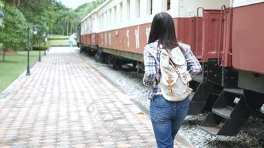 镜头快乐亚洲旅游女人铁路站走火车一步楼梯旅行亚洲古董火车休闲旅游旅行火车运输复古的颜色