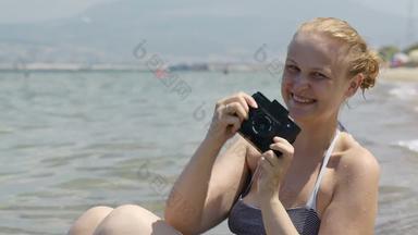 微笑女人采取照片海边古董相机