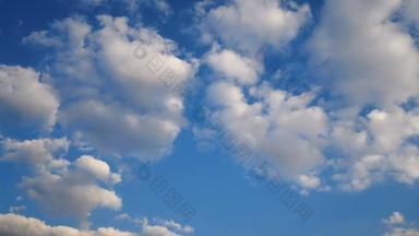 镜头蓝色的天空白色蓬松的云金光日落日出时间多云的一天相机锅移动