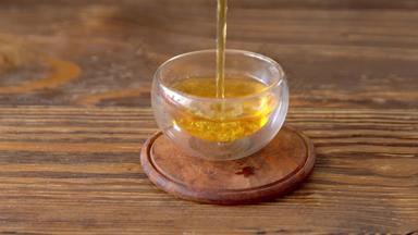 关闭倒乌龙茶茶茶壶玻璃杯木表格服务酿造绿色茶玻璃碗茶投手传统的茶仪式