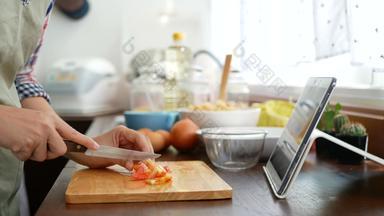 女人切片红色的番茄准备成分烹饪遵循烹饪在线视频剪辑网站平板电脑烹饪内容互联网技术现代生活方式