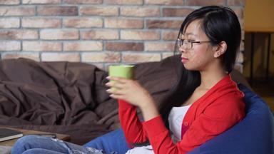 年轻的女人喝茶绿色杯子咖啡馆