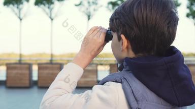 可爱的男孩检查社区双筒望远镜