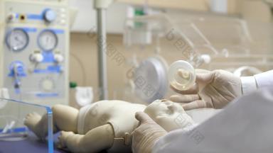 医生把氧气面具新生儿婴儿辐射温暖的使复活单位人体模型模型