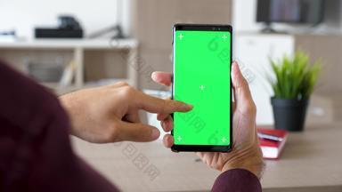 男人。手滚动智能手机绿色屏幕浓度模拟