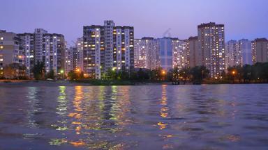 公寓建筑位于湖日落紫色的天空反映水电消费时间孩子晚上城市灯反映水河湖