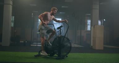 健身男人。自行车旋转健身房适合年轻的男性工作健身房自行车男性锻炼自行车健康俱乐部