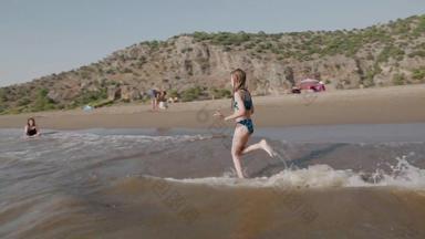 慢运动快乐女孩运行海水绿色高地景观快乐的少年girlrunning森迪海滩溅海水夏天假期