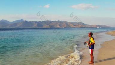 钓<strong>鱼杆</strong>好的家伙旅行挂海滩阳光明媚的蓝色的白色沙子背景