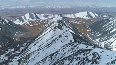 雪山阳光明媚的一天空中视图无人机飞行落后的山脊相机倾斜建立拍摄高高度