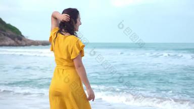 纤细的年轻的美丽的浅黑肤色的女人女孩黄色的衣服享受风微风走海滩湾