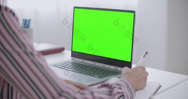 年轻的女人学习写作字帖查看绿色屏幕移动PC浓度关键技术