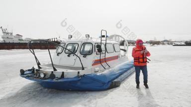 女人橙色夹克移动气垫船背景气垫船冻水冬天湖冬天船冰冷的湖