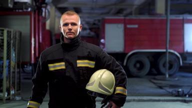 消防队员视频肖像穿统一的持有黄色的保护头盔火卡车背景相机平移左