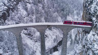landwasser高架桥铁路火车冬天下雪瑞士阿尔卑斯山脉瑞士空中视图无人机苍蝇向后向上揭示拍摄